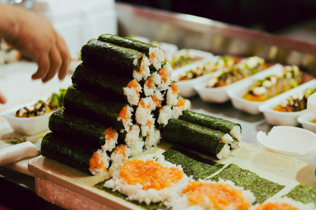 Freshly made sushi rolls stacked neatly on a restaurant counter