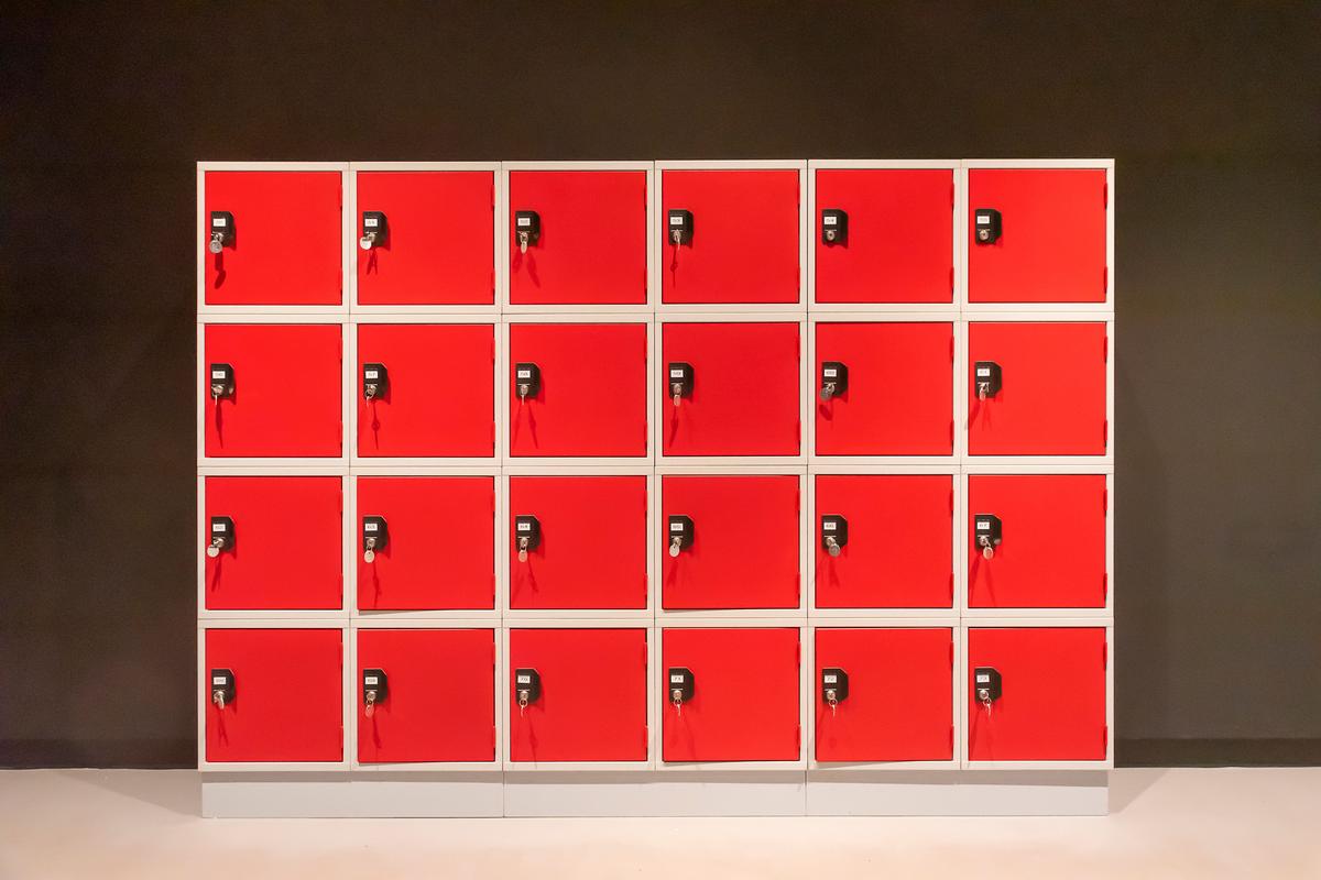 A cabinet of red lockers with combination locks